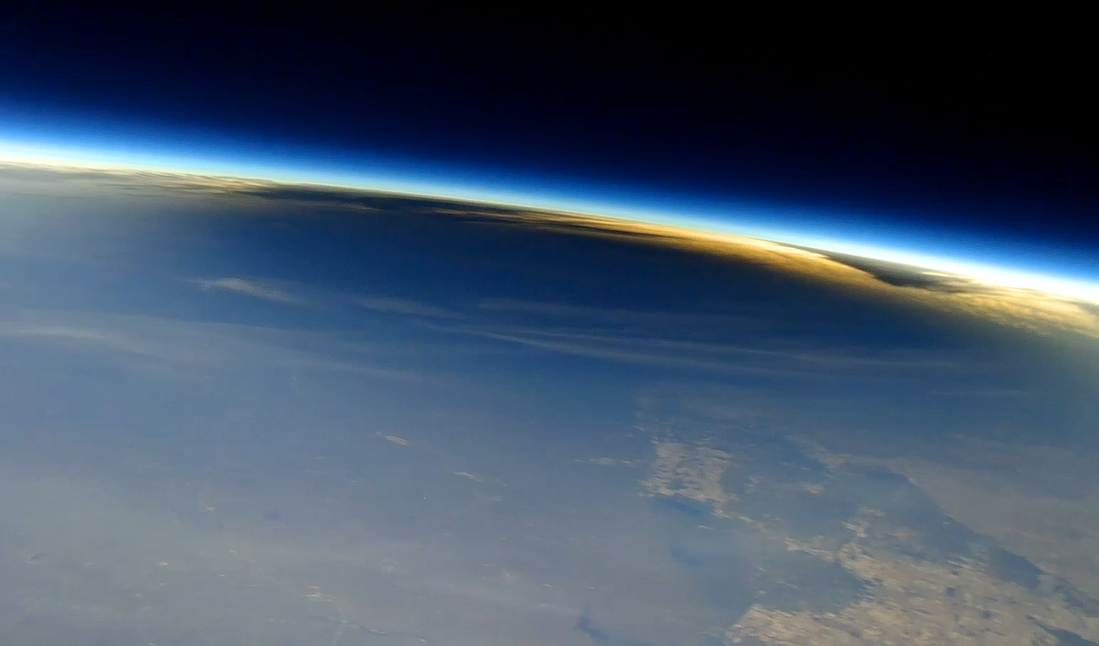 Earth’s curved horizon and thin blue atmosphere viewed from orbit